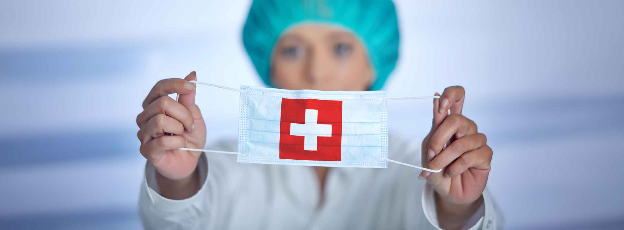Fachfrau Operationstechnik mit Maske mit Schweizerkreuz